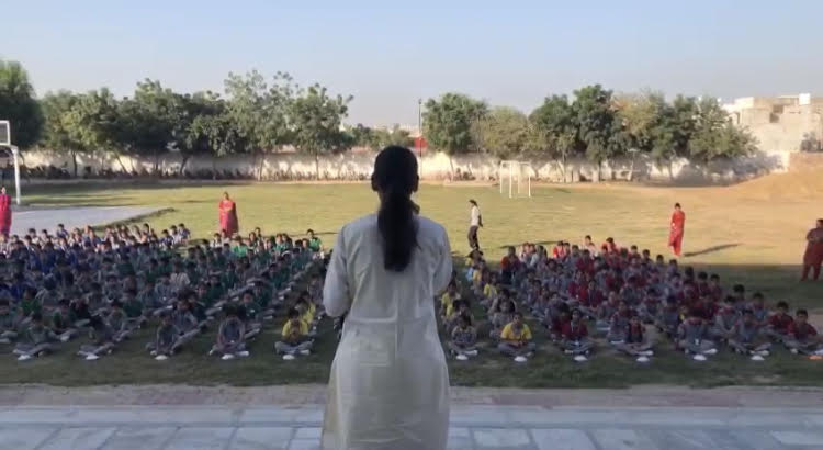 Krati teaching children, school grounds